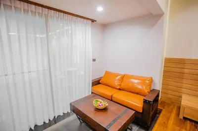 a living room with an orange leather couch and a table at Malabar Pool Villa Phuket in Phuket Town