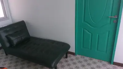a green door and a black chair in a room at RadHut in Chalong