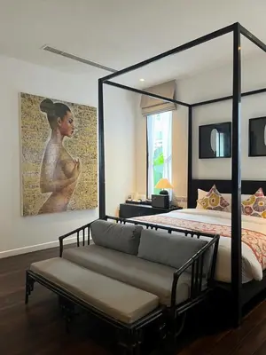 a bedroom with a bed and a couch and a painting at Yao Bada Badoo Boutique Resort in Ko Yao Yai