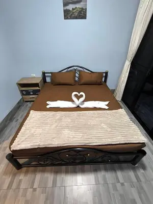 a bed with two white towels on top of it at PhuketAirportCamping in Mai Khao Beach