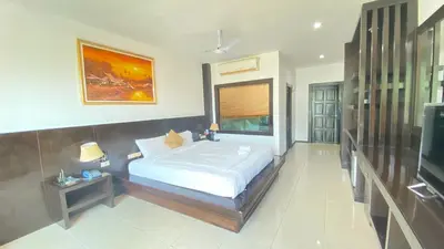 a bedroom with a bed and a television in it at SM Patong Resort in Patong Beach