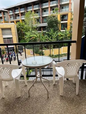 a table and chairs on a balcony with a view of a building at Rawai Sea Beach in Phuket Town