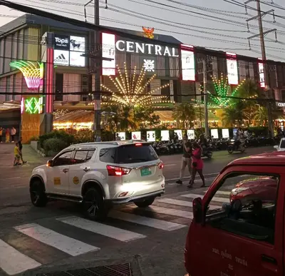 a white suv parked in front of a shopping center at STPhostel in Patong Beach