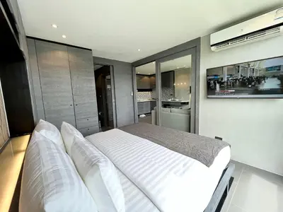a bedroom with a white bed and a tv at Kamala Beach P79 Exclusive Junior Suite in Kamala Beach