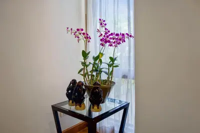 a glass table with a vase with purple flowers on it at Laguna Luxury 2-Bed Pool Villa - Near Layan Beach in Layan Beach