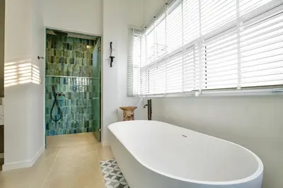 a bath tub in a bathroom with a shower and a window at Nai Harn Beach 4 bedroom Pool Villa, Rawai, Phuket in Phuket Town
