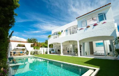 a white house with a swimming pool in front of it at Nai Harn Beach 4 bedroom Pool Villa, Rawai, Phuket in Phuket Town