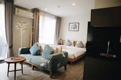 a bedroom with a bed and a couch and a chair at The Deck Condo Studios Patong w/ pool fitness in Patong Beach