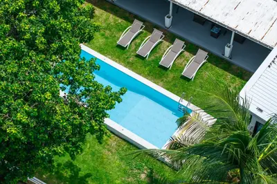 an overhead view of a swimming pool with lounge chairs at mona seaview pool villa beach front AoYon Beach in Panwa Beach