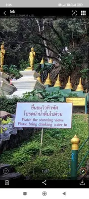 a sign in front of a building with a statue at Baan Thara Guesthouse in Ao Nang Beach