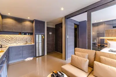a living room with a couch and a kitchen at Kamala Beach P15 Pool view Suite in Kamala Beach