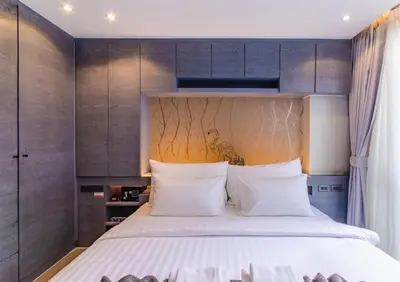 a bedroom with a large bed and wooden cabinets at Kamala Beach P15 Pool view Suite in Kamala Beach