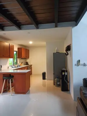 a kitchen with a refrigerator and a table in it at Villa B23 Phuket in Nai Yang Beach