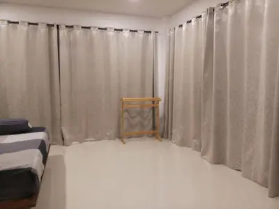 a room with a bed and a window with curtains at Villa B23 Phuket in Nai Yang Beach