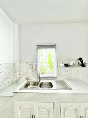 a white kitchen with a sink and a window at Lay Back Villa C4 in Ban Nong Thale