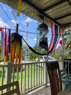 a porch with flags and chairs on a fence at Lay Back Villa C4 in Ban Nong Thale