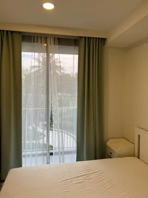 a bedroom with a bed and a large window at Skypark view golf Laguna Phuket in Bang Tao Beach