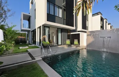 a villa with a swimming pool in front of a house at Laguna Park 2 in Phuket Town