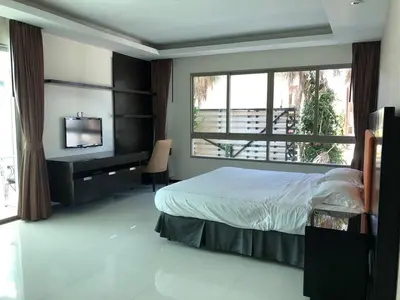 a bedroom with a bed and a desk and a window at Kamala Regent : Beautiful Modern Apartment close to Kamala beach in Kamala Beach