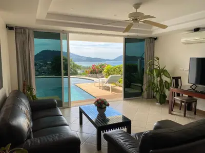 a living room with a couch and a table at Andaman Hill Pool Seaview in Patong Beach