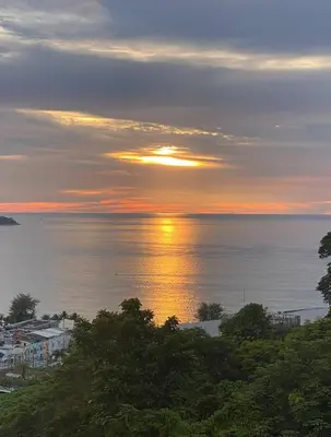 a sunset over the ocean with the sun setting at Andaman Hill Pool Seaview in Patong Beach