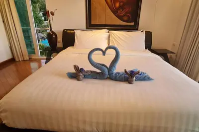 two swans making a heart on a bed at Kata Ocean View Luxury condo & Seaview K12 in Kata Beach