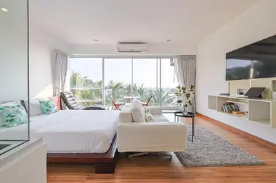 a bedroom with a white bed and a white couch at Sunset Residence Karon Beach in Karon Beach