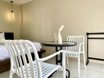 two white chairs and a table with a vase on it at Mamatel boutique in Kamala Beach