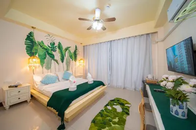 a bedroom with a bed and a dresser in it at Patong Beach Side Hotel in Patong Beach