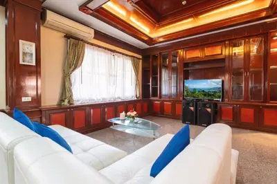 a living room with a white couch and a tv at The Phuket Pool Villa in Phuket Town
