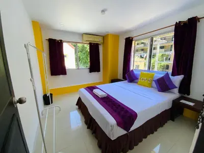 a bedroom with a bed with purple and yellow walls at Patong Sea U in Patong Beach