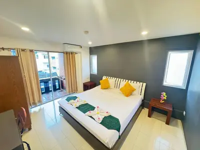a bedroom with a bed with yellow and green pillows at Patong Sea U in Patong Beach