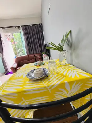 a dining room table with a yellow table cloth at Phuket naka Condon-41\u65e0\u8fb9\u6cf3\u6c60\u514d\u8d39\u4e0a\u7f51\u514d\u8d39\u505c\u8f66\u4f4d in Phuket Town