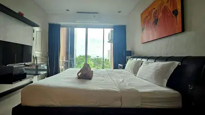 a dog sitting on top of a bed in a room at Апартаменты с видом на море на Карон Бич А 509 in Karon Beach