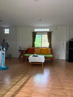 a living room with a couch and a table at Thanid House in Ban Nai Khlong