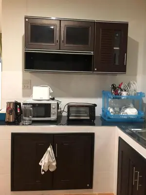 a kitchen counter with a microwave and a toaster oven at Thanid House in Ban Nai Khlong