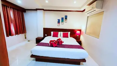 a bedroom with a large bed with red pillows at \u6c34\u679c\u5929\u5802\u65c5\u9986Fruit Paradise in Patong Beach