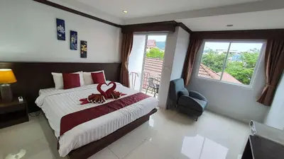 a bedroom with a large bed with a large window at \u6c34\u679c\u5929\u5802\u65c5\u9986Fruit Paradise in Patong Beach