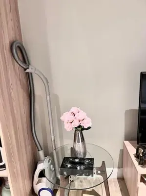 a glass table with a vase of pink flowers on it at Diamond Apartments Phuket Bangtao in Phuket Town