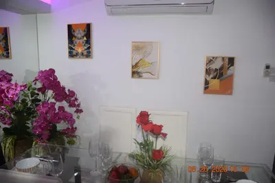 a white wall with flowers in vases on a table at kalim residence 217 vue partielle mer in Patong Beach