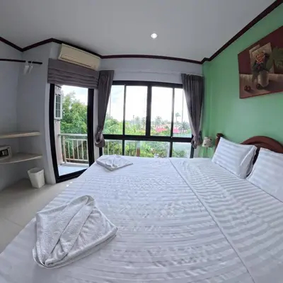 a bedroom with a large white bed with a window at Hotel premier in Patong Beach