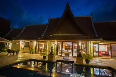 a villa with a swimming pool at night at VILLA SIRINTHARA in Rawai Beach