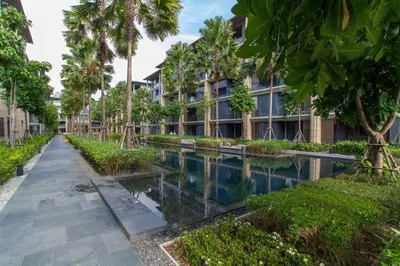 an apartment complex with a canal in front of a building at Baan Mai Khao by Villacarte in Mai Khao Beach