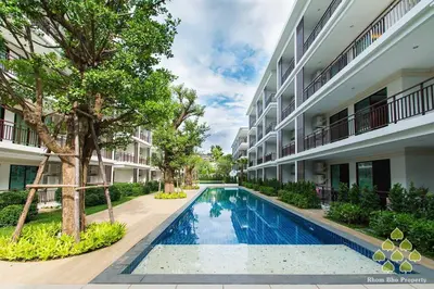 an apartment complex with a swimming pool in front of a building at Title III and II by Villacarte in Rawai Beach