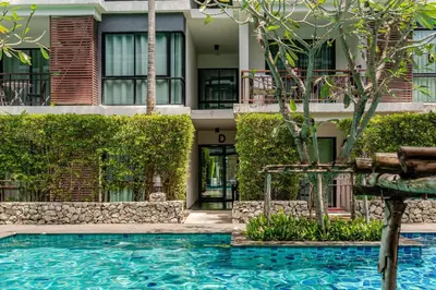 a hotel with a swimming pool in front of a building at Title III and II by Villacarte in Rawai Beach