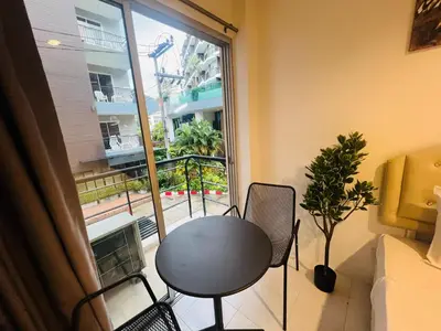 a room with a table and chairs and a large window at Omaya GuestHouse in Patong Beach