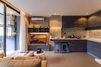 a living room with a couch and a kitchen at Kamala D38 Exclusive Junior Suite in Kamala Beach
