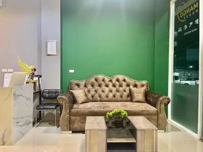 a living room with a brown couch and a table at Studio room in Mango House in Phuket Town