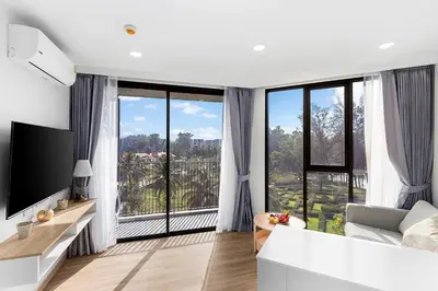 a living room with a large window with a view at Laguna Skypark by My Home Phuket in Bang Tao Beach