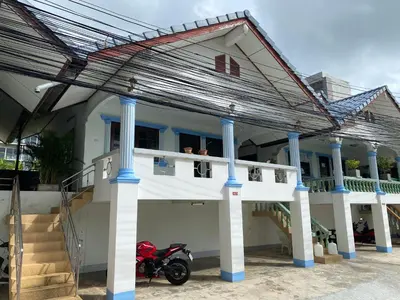a house with a motorcycle parked in front of it at Vacation Home Tambon Karon in Karon Beach